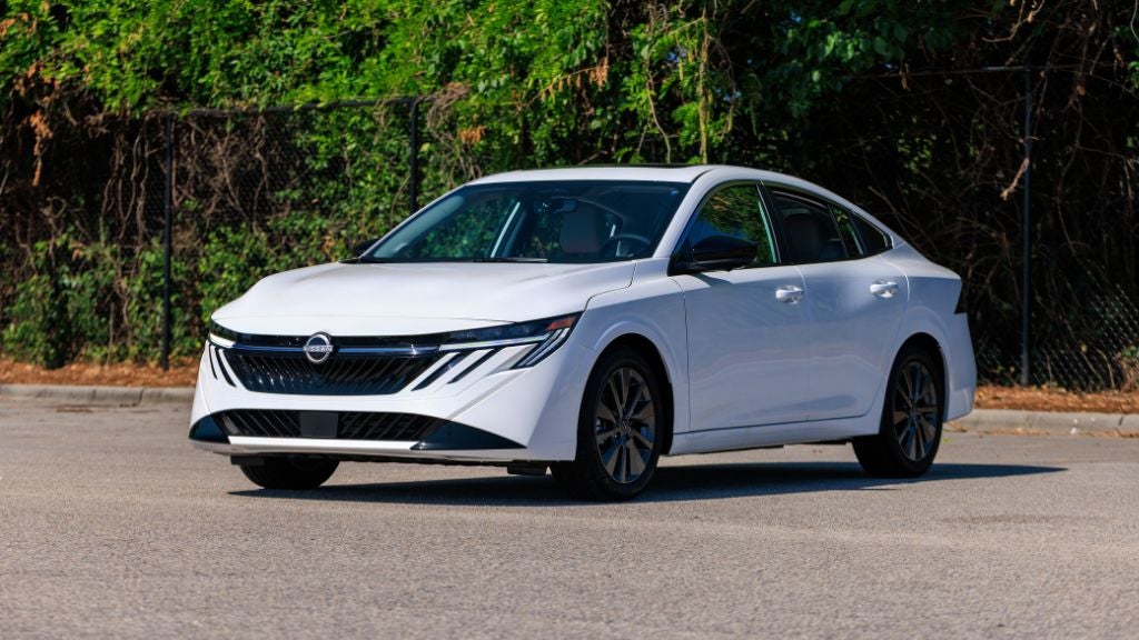 White 2026 Nissan Sentra parked on a lot with trees in the background