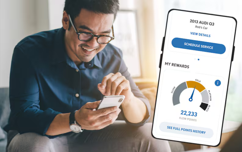 A person sitting an using their phone. There is a screenshot of the Flow Garage mobile app