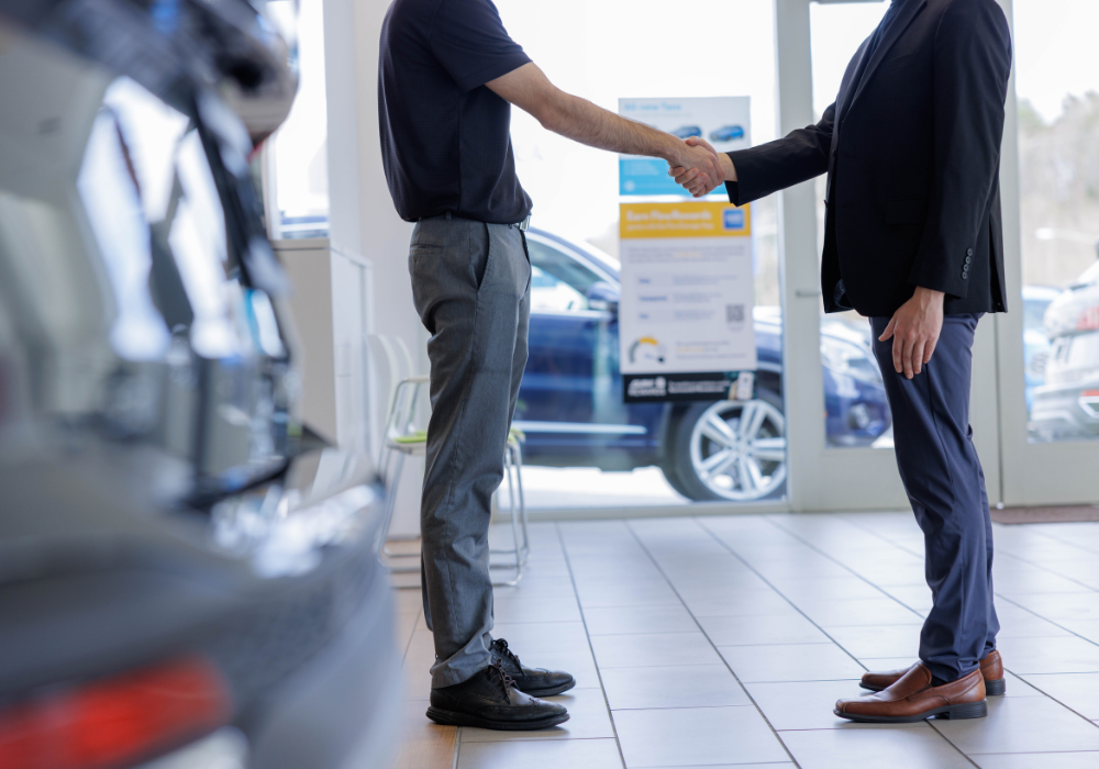 Two people shaking hand inside the Flow Nissan of Statesville dealership