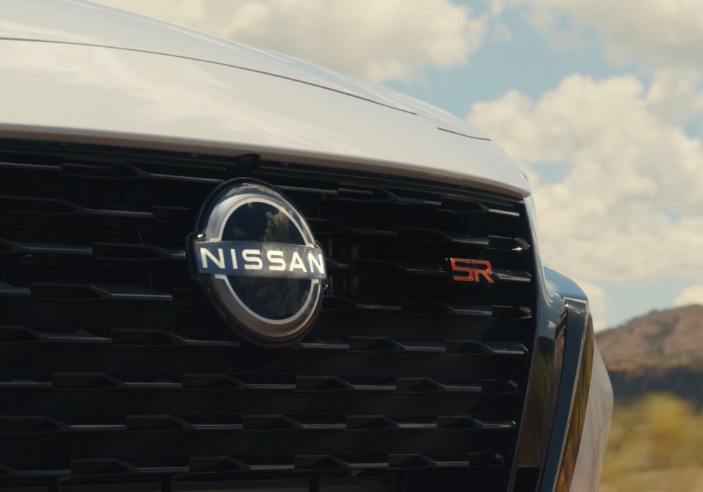 Close up photo of the front grille of a gray Nissan vehicle