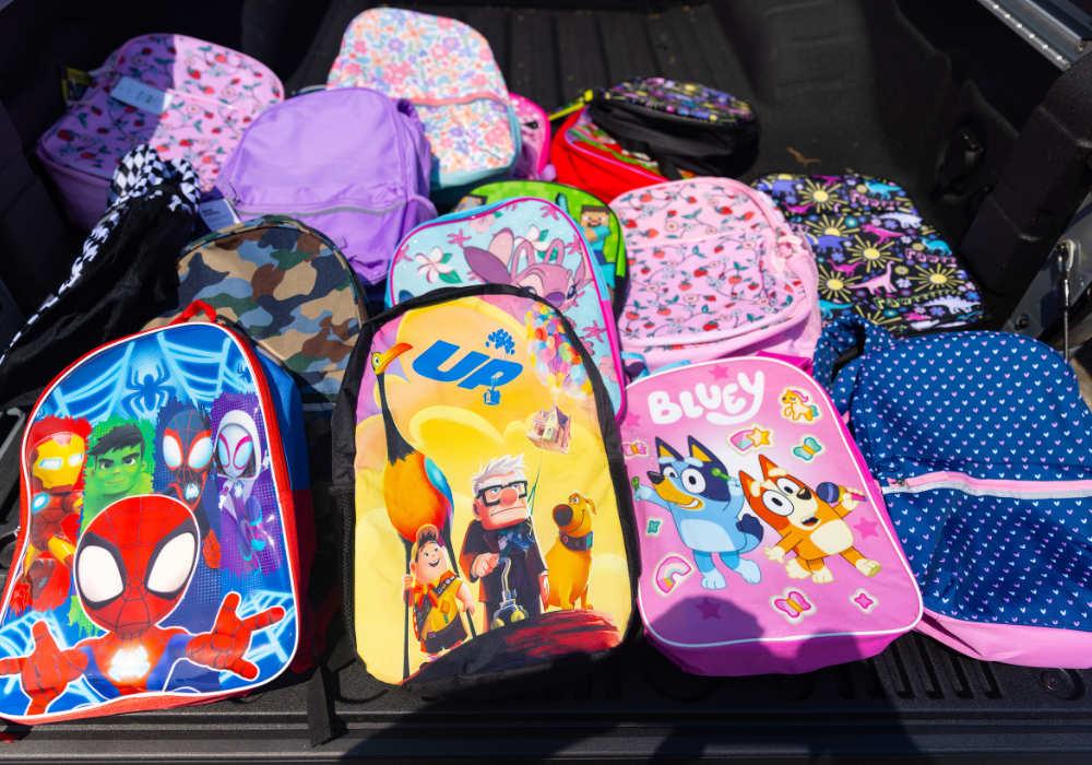 Several colorful children's backpacks in the bed of a truck at Flow Nissan of Statesville