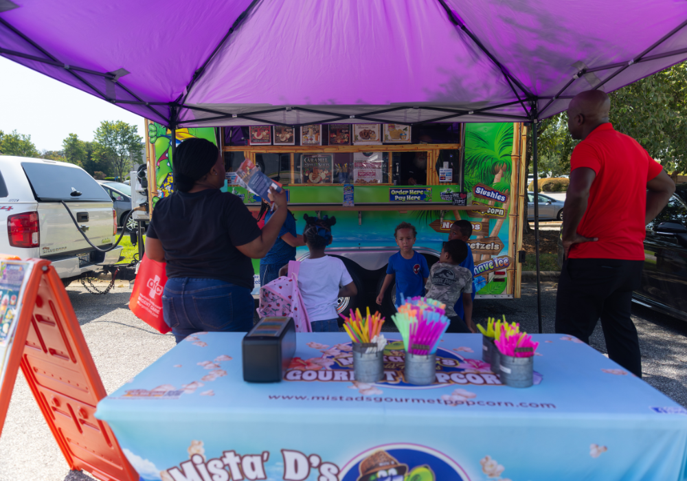 A group of people standing around a food truck